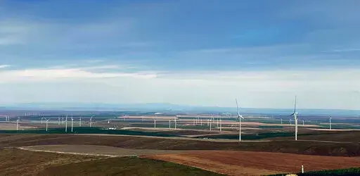 In this photo provided by Portland General Electric, windmills are seen at a renewable energy facility in Lexington, Ore., May 24, 2022, that combines solar power, wind power and massive batteries to store the energy generated there. The Wheatridge Renewable Energy Facilities was commissioned Wednesday, Sept. 28, 2022, and is the first utility-scale plant of its kind in North America. Clean energy experts say the project, which can power 100,000 homes, addresses some key challenges facing the in
