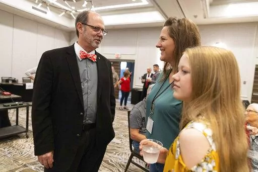 From left, Douglas Frank chats with Melissa Sauder and her daughter, Anley, 13, of Grant, Neb., before the start of the Nebraska Election Integrity Forum on Saturday, Aug. 27, 2022, in Omaha, Neb. (AP Photo/Rebecca S. Gratz)