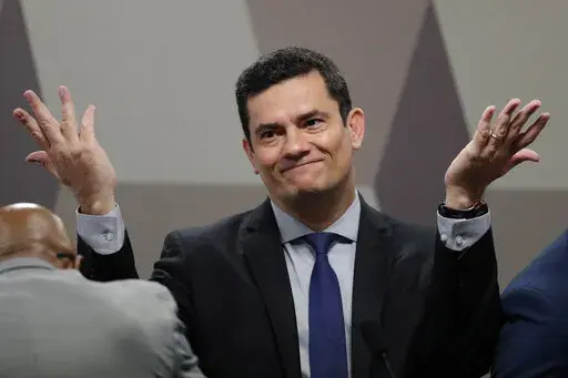 Brazil's Justice Minister Sergio Moro throws his hands up as he arrives to testify before a Senate commission, in Brasilia, Brazil, Wednesday, June 19, 2019. When Moro resigned to enter politics, many in Brazil believed the anti-corruption crusader who jailed da Silva could someday occupy the nation’s most powerful office. But on the eve of Brazil’s Oct. 2, 2022 general election, the once-revered magistrate was fighting what polls showed was a losing battle for a Senate seat. (AP Photo/Erald