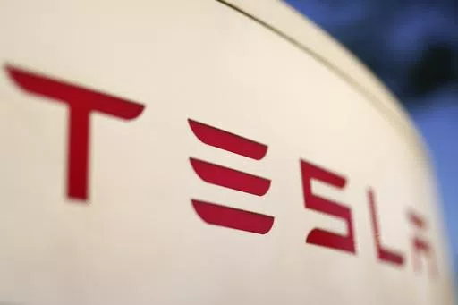 The logo for the Tesla Supercharger station is seen in Buford, Ga, April 22, 2021. Faced with falling global sales and a tumbling stock price, Tesla has slashed prices again on some of its electric vehicles and its “Full Self Driving” system. Tesla releases first-quarter earnings Tuesday, April 23, 2024. (AP Photo/Chris Carlson, File)