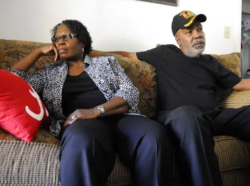 Sarah Collins Rudolph and her husband, George Rudolph, talk in their home on Nov. 16, 2016, in Birmingham, Ala. Rudolph lost an eye and still has slivers of glass inside her body from the racist bombing that killed her sister and three other Black girls inside a church 59 years ago Thursday. She's still waiting on the state to compensate her for those injuries. (AP Photo/Jay Reeves, File)