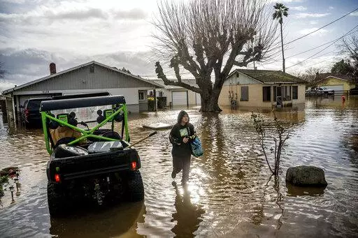 Brenda Ortega, 15, salvages items from her flooded Merced, Calif., home on Tuesday, Jan. 10, 2023. In California, only about 230,000 homes and other buildings have flood insurance policies, which are separate from homeowners insurance. (AP Photo/Noah Berger, File)