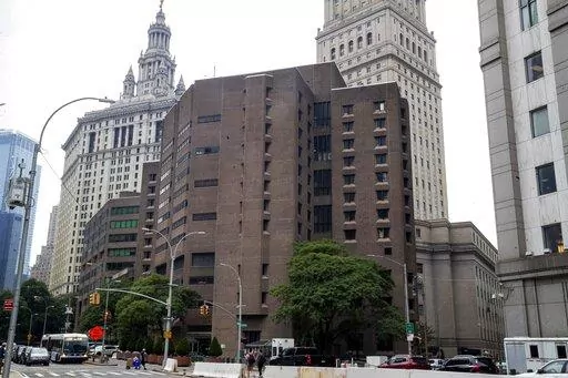 The brown bricked Metropolitan Correctional Center is shown in the foreground with municipal and court facilities in the background, Aug. 13, 2019, in New York. A federal correctional officer was arrested Friday, March 18, 2022, for lying to investigators after a loaded gun was found in an inmate's cell at the federal jail — the same lockup where Jeffrey Epstein killed himself in 2019. (AP Photo/Mary Altaffer, File)