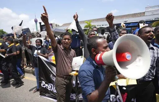 Sri Lankans representing various government establishments shout slogans against the government during a protest in Colombo, Sri Lanka, Wednesday, April 20, 2022. Thousands of people across Sri Lanka are taking to the streets, a day after police opened fire at demonstrators, killing one person and injuring 13 others, reigniting widespread protests amid the country's worst economic crisis in decades. Placards reads demands against privatisation and increasing  costs of living. (AP Photo/Eranga Ja