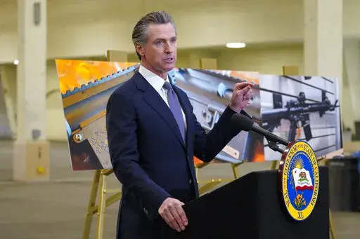California Gov. Gavin Newsom, along with several elected officials, meets with the media at Del Mar Fairgrounds on Friday, Feb. 18, 2022, in Del Mar, Calif., where he backed state legislation that would allow for private citizens to enforce the state's ban on assault weapons. A U.S. appeals court ruled Wednesday, May 11 that California’s ban on the sale of semiautomatic weapons to adults under 21 is unconstitutional.  (Nelvin C. Cepeda/The San Diego Union-Tribune via AP, File)