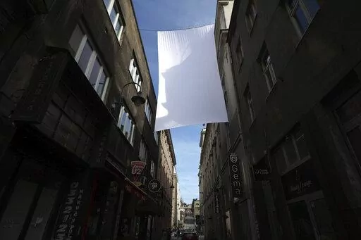A cloth representing sniper protection screen is displayed in downtown in Sarajevo, Bosnia, Monday, April 4, 2022. Sarajevo is paying a subdued tribute to the resilience of its citizens who survived the longest military siege in modern history, and commemorating thousands of others who did not. Many of the survivors said they found the 30th anniversary of the start of the siege of the Bosnian capital particularly hard because they are marking it against the backdrop of what they describe as simi