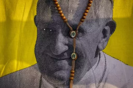 A necklace showing the Virgin Mary is seen around the neck of a woman wearing a t-shirt with a picture of Pope Francis, as she awaits his arrival at the St. Theresa Cathedral in Juba, South Sudan, Saturday, Feb. 4, 2023. In an extraordinary pushback against Pope Francis, Catholic bishops from Africa to Poland say they will not implement a new Vatican policy allowing blessings for same-sex couples. (AP Photo/Ben Curtis, File)