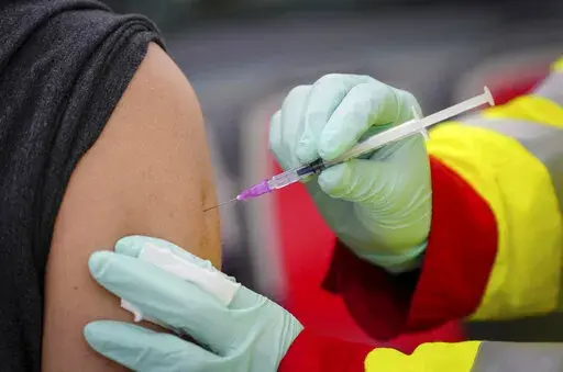 A person is vaccinated with the Pfizer vaccine against the coronavirus and the COVID-19 disease at vaccination bus in Berlin, Germany, Tuesday, Nov. 23, 2021. Germany battles rising numbers of coronavirus infections. (Kay Nietfeld/dpa via AP)