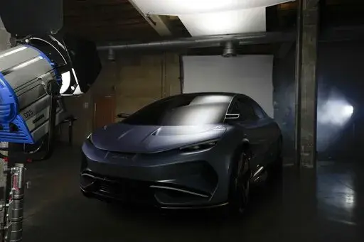 The Aehra new electric vehicle is lit on a set for a photo shoot in Milan, Italy, Thursday, Oct. 20, 2022. Tesla paved the way nearly two decades ago. Now the road to full-electric vehicle transition is littered with startups, inspired by a new era in mobility, and drawn by the lower cost of building EVs compared with their fossil-fuel guzzling forbears. (AP Photo/Luca Bruno)