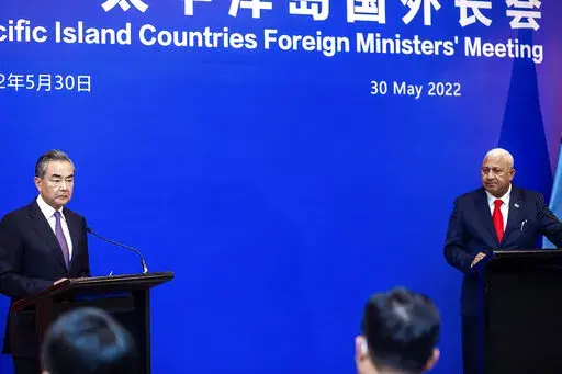 China's Foreign Minister Wang Yi, left, appears on stage at the Pacific Islands Foreign Ministers' meeting with Fiji's Prime Minister Frank Bainimarama, Monday, May 30, 2022, in Suva, Fiji. (Leon Lord/Fiji Sun via AP)