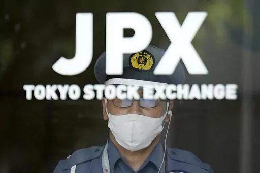 A security guard stands guard at an entrance of Tokyo Sock Exchange building Tuesday, July 18, 2023, in Tokyo. (AP Photo/Eugene Hoshiko)