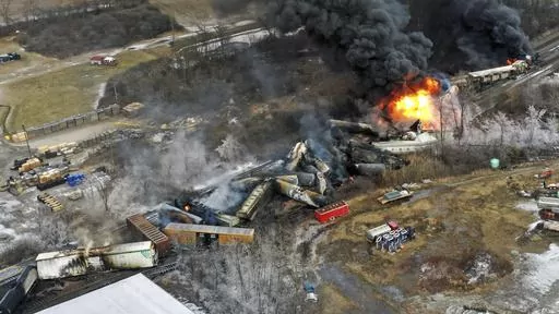 In this photo taken with a drone, portions of a Norfolk Southern freight train that derailed the previous night in East Palestine, Ohio, remain on fire at mid-day, Feb. 4, 2023. The Pipelines and Hazardous Materials Safety Administration proposed a new rule Wednesday, June 21, that would require all railroads to quickly provide the details of everything aboard their trains electronically to every emergency responder within 10 miles of a derailment. (AP Photo/Gene J. Puskar, File)