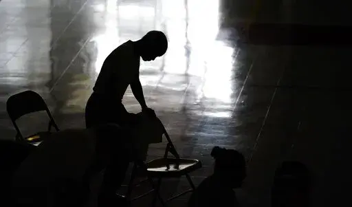 A man prays during Mass in the gymnasium at St. Joan of Arc Catholic Church in LaPlace, La., Sunday, Sept. 5, 2021, in the aftermath of Hurricane Ida. ​(AP Photo/Matt Slocum)