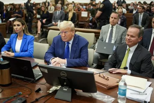 Former President Donald Trump, center, flanked by his defense attorneys, Alina Habba, left, and Chris Kiss, waits for the continuation of his civil business fraud trial at New York Supreme Court, Oct. 25, 2023, in New York. Trump's testimony on Monday will produce a rare spectacle of a former president being summoned to the stand as a trial witness. But Trump has actually had ample experience fielding questions from lawyers. His rhetorical style during years of depositions before becoming presid