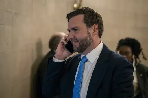 Vice President-elect JD Vance speaks on his mobile phone as he arrives for private meetings at the Capitol in Washington, Wednesday, Nov. 20, 2024. (AP Photo/Ben Curtis)