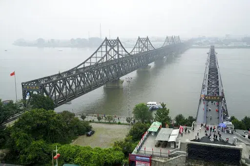 Visitors walk across the Yalu River Broken Bridge, right, next to the Friendship Bridge connecting China and North Korea in Dandong in northeastern China's Liaoning province, Sept. 9, 2017. After spending two years in a strict lockdown because of the COVID-19 pandemic, North Korea may finally be opening up — slowly. The reason could reflect a growing sense of recognition by the leadership that the nation badly needs to win outside economic relief. (AP Photo/Emily Wang, File)