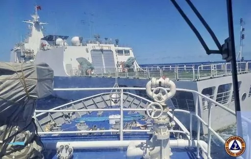 In this photo provided by the Philippine Coast Guard, a Chinese Coastguard ship, front, allegedly blocks the path of a Philippine Coast Guard ship near the Philippine-occupied Second Thomas Shoal, South China Sea during a re-supply mission on Saturday Aug. 5, 2023. The Philippine military condemned on Sunday a Chinese coast guard ship's "excessive and offensive" use of a water cannon to block a Filipino supply boat from delivering new troops, food, water and fuel to a Philippine-occupied shoal i
