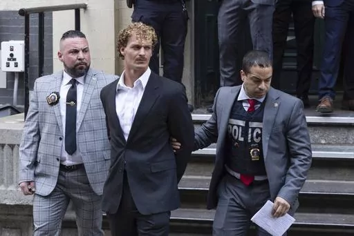 Daniel Penny, center, is walked by New York Police Department detectives out of the 5th Precinct on May. 12, 2023, in New York. Republican presidential hopefuls have rushed to support Penny, a white U.S. Marine veteran who was caught on video pinning an agitated Black subway passenger to the floor in a fatal chokehold.(AP Photo/Jeenah Moon, File)