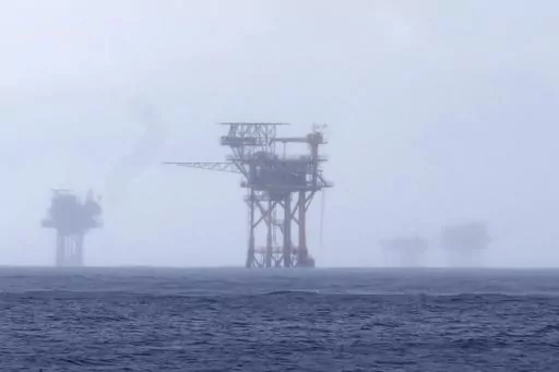 CORRECTS TO 382 MILLION NOT 328 FILE - Oil platforms are visible through the haze near the Flower Garden Banks National Marine Sanctuary in the Gulf of Mexico, off the coast of Galveston, Texas, Sept. 16, 2023. Oil companies offered $382 million for drilling leases in the Gulf Wednesday after courts rejected the Biden administration's plans to scale back the sale to protect an endangered whale species. (AP Photo/LM Otero, file)