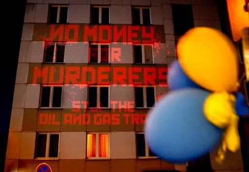 The words "No Money for Murderers, Stop the Oil and Gas Trade" are projected by activists onto the Russian consulate in Frankfurt, Germany, April 4, 2022. Europe is discussing a boycott of Russian oil over the Kremlin's invasion of Ukraine. As Russia's biggest customer for oil, the 27-country European Union could deal a blow to President Vladimir Putin's state finances. But Europe would face higher prices and such a move would send an oil shock through a global economy that's still rebounding fr
