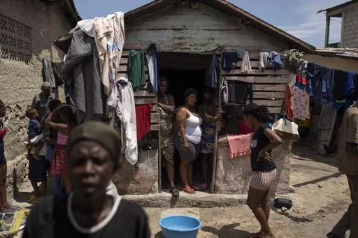 People displaced by gang violence stand in Jean-Kere Almicar's front yard, where they have sought refuge, in Port-au-Prince, Haiti, Sunday, June 4, 2023. Nearly 200 people who once lived in the Cite Soleil slum near Almicar’s house are now camped out in his front yard and nearby areas. They are among the nearly 165,000 Haitians who have fled their homes amid a surge in gang violence. (AP Photo/Ariana Cubillos)