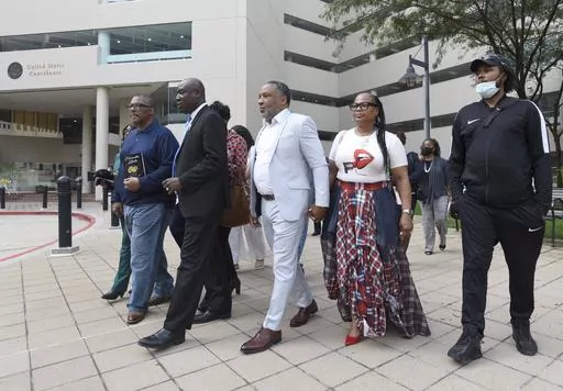 Attorney Ben Crump, second from left, walks with Ron Lacks, left, Alfred Lacks Carter, third from left, both grandsons of Henrietta Lacks, and other descendants of Lacks, outside the federal courthouse in Baltimore, Oct. 4, 2021. The family of Henrietta Lacks is settling a lawsuit against a biotechnology company it accuses of improperly profiting from her cells. Their federal lawsuit in Baltimore claimed Thermo Fisher Scientific has made billions from tissue taken without the Black woman’s con