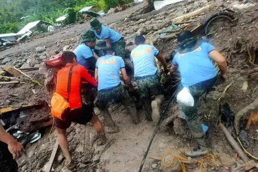 In this handout photo provided by the Philippine Coast Guard, rescuers retrieve bodies during the search and rescue operations due to landslides caused by Tropical Storm Nalgae in Barangay Kushong, Datu Odin Sinsuat, Maguindanao province, southern Philippines on Friday Oct. 28, 2022. Several people died while others were missing in flash floods and landslides set off by torrential rains from Tropical Storm Nalgae that swamped a southern Philippine province overnight and trapped some residents on