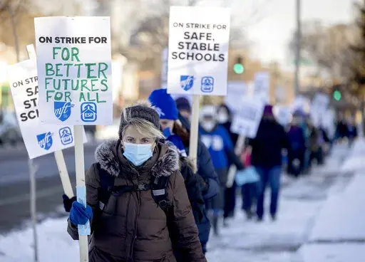 Minneapolis teachers and supporters picket at 34th street and Chicago Avenue South in Minneapolis, on Tuesday, March 8, 2022.  Teachers in Minneapolis have reached a tentative agreement to end a more than two-week strike over pay and other issues that idled some 29,000 students and around 4,500 educators and staff. The district and the union for teachers and staff announced the deal early Friday, March 25. (Elizabeth Flores /Star Tribune via AP)