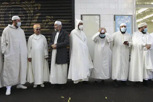 Imams from the Paris Mosque gather before paying their homage to the victims of the Nov. 13, 2015 attacks, near the Bataclan concert hall in Paris, Friday, Nov.12, 2021. The French government on Saturday, Feb. 5, 2022, forged ahead with efforts to reshape Islam in France and rid it of extremism, introducing a new body made up of clergy and laymen — and women — to help lead the largest Muslim community in western Europe. (AP Photo/Adrienne Surprenant, File)