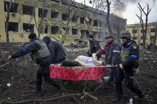 Ukrainian emergency employees and volunteers carry an injured pregnant woman from a maternity hospital that was damaged by shelling in Mariupol, Ukraine, March 9, 2022. The woman and her baby died after Russia bombed the maternity hospital where she was meant to give birth. (AP Photo/Evgeniy Maloletka, File)