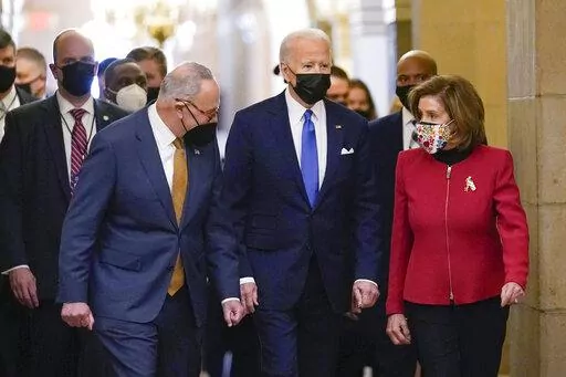 President Joe Biden is flanked by Senate Majority Leader Chuck Schumer of N.Y., left, and House Speaker Nancy Pelosi of Calif., right, after arriving on Capitol Hill in Washington, Jan. 6, 2022.  Biden will give his State of the Union address to Congress on March 1. (AP Photo/Susan Walsh, File)