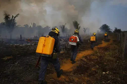 Fire brigade members walk in to a burnt area in Apui, Amazonas state, Brazil, Sept. 21, 2022. Despite the smoke clogging the air of entire Amazon cities, state elections have largely ignored environmental issues. Far-right President Jair Bolsonaro is seeking a second four-year term against leftist Luiz Inácio Lula da Silva, who ruled Brazil between 2003 and 2010. (AP Photo/Edmar Barros, File)