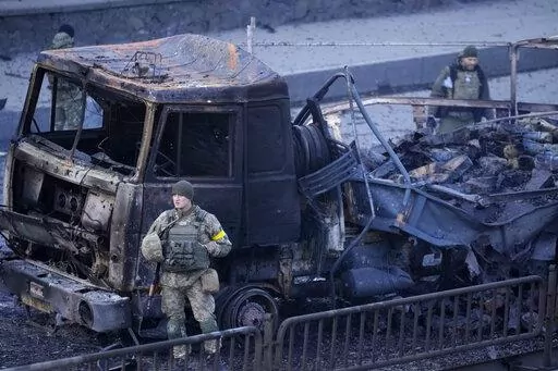 Ukrainian troops inspect the site following a Russian airstrike in Kyiv, Ukraine, Saturday, Feb. 26, 2022. (AP Photo/Vadim Ghirda)