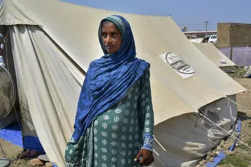 Shakeela Bibi who is pregnant stands beside her tent at a relief camp for flood victims, in Fazilpur near Multan, Pakistan, Sept. 23, 2022. Pregnant women are struggling to get care after Pakistan’s unprecedented flooding, which inundated a third of the country at its height and drove millions from their homes. The UN says around 130,000 pregnant women in flood-hit areas require urgent healthcare and more than 2,000 are giving birth every day, most in unsafe conditions. (AP Photo/Shazia Bhatti