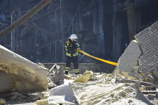 An Ukrainian firefighter works near a destroyed building on the outskirts of Odesa, Ukraine, Tuesday, May 10, 2022. The Ukrainian military said Russian forces fired seven missiles a day earlier from the air at the crucial Black Sea port of Odesa, hitting a shopping center and a warehouse.  (AP Photo/Max Pshybyshevsky)