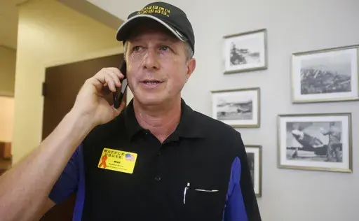 Walt Ehmer, president and CEO of Waffle House, speaks on the phone after landing at the Wilmington airport with an emergency response team in Wilmington, N.C., Sept. 17, 2018. (AP Photo/Steve Helber, File)