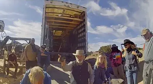 In this image from video released by the Santa Fe County Sheriff's Office, Alec Baldwin gestures while talking with investigators following a fatal shooting last year on a movie set in Santa Fe, New Mexico. Law enforcement officials have released a trove of video and photographic evidence in the investigation of a fatal October shooting of a cinematographer by actor and producer Alec Baldwin on the set of a Western movie. Data files released by the Santa Fe County Sheriff's Office on Monday, Apr