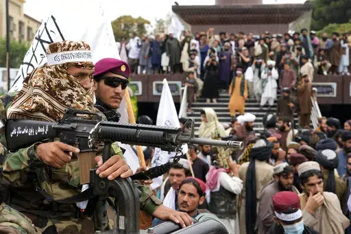 Taliban fighters celebrate one year since they seized the Afghan capital, Kabul, in front of the U.S. Embassy in Kabul, Afghanistan, Monday, Aug. 15, 2022. The Taliban marked the first-year anniversary of their takeover after the country's western-backed government fled and the Afghan military crumbled in the face of the insurgents' advance. (AP Photo/Ebrahim Noroozi)
