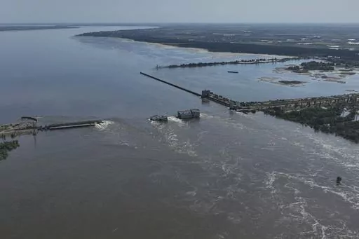 CAPTION CORRECTS LOCATION - Water flows over the collapsed Kakhovka Dam in Nova Kakhovka, in Russian-occupied Ukraine, Wednesday, June 7, 2023. (AP Photo)