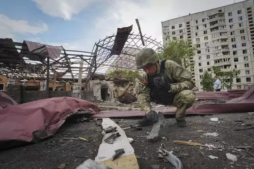 A sapper inspects fragments of a Russian air bomb that hit a living area injuring ten in Kharkiv, Ukraine, May 22, 2024. Two U.S. officials say the Biden administration is expected to announce an additional $275 million in military aid for Ukraine on Friday. It comes as Kyiv struggles to hold off advances by Russian troops in the Kharkiv region. This will be the fourth installment of military aid for Ukraine since Congress passed a long-delayed foreign aid bill late last month.(AP Photo/Andrii M