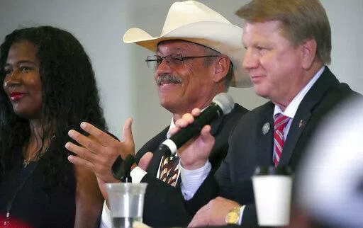 From left, Kristina Karamo, candidate for Michigan Secretary of State, Mark Finchem, candidate for Arizona Secretary of State and Jim Marchant, candidate for Nevada Secretary of State, attend a conference on conspiracy theories about voting machines and discredited claims about the 2020 presidential election at a hotel in West Palm Beach, Fla., Saturday, Sept. 10, 2022. The event featured Republicans running for statewide offices that oversee elections in some of the most important battleground 