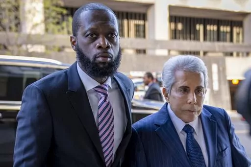 Prakazrel "Pras" Michel, left, a member of the 1990s hip-hop group the Fugees, accompanied by defense lawyer David Kenner, right, arrives at federal court for his trial in an alleged campaign finance conspiracy, Thursday, March 30, 2023, in Washington. Michel, who was accused in multimillion-dollar political conspiracies spanning two presidencies, was convicted Wednesday, April 26, after a trial that included testimony ranging from actor Leonardo DiCaprio to former U.S. Attorney General Jeff Ses