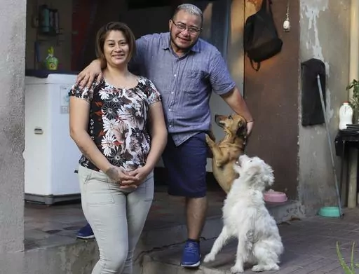 Fabricio Chicas, a transgender man, right, poses for a photo with his partner Elizabeth Lopez, and their pets, at their home in San Salvador, El Salvador, Sunday, April 30, 2023. Even though the country’s Supreme Court in 2022 determined that the inability of a person to change their name because of gender identity constitutes discriminatory treatment, the 49-year-old has not been able to change his name from Patricia to Fabricio, nor his gender on his ID, a fate shared by many transgender peo