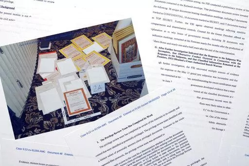 Pages from a Department of Justice court filing on Aug. 30, 2022, in response to a request from the legal team of former President Donald Trump for a special master to review the documents seized during the Aug. 8 search of Mar-a-Lago, are photographed early Wednesday, Aug. 31, 2022. Included in the filing was a FBI photo of documents that were seized during the search. (AP Photo/Jon Elswick)