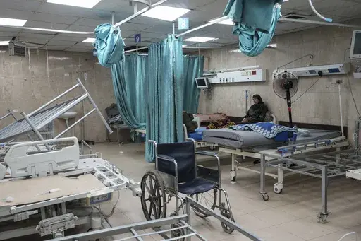 A woman sits on a bed in a room of the Al-Aqsa Martyrs hospital in Deir al Balah, Gaza Strip, Aug. 25, 2024. (AP Photo/Abdel Kareem Hana, File)