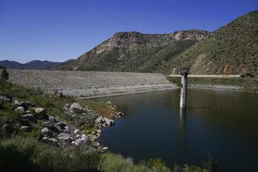 The dam at El Capitan Reservoir is seen Friday, April 8, 2022, in Lakeside, Calif. Constructed four generations ago, the massive rock and clay dam is capable of storing over 36 billion gallons of water — enough to supply every resident in San Diego for most of a year. Today, it's three-quarters empty — intentionally kept low because of concerns it could fail under the strain of too much water. (AP Photo/Gregory Bull)