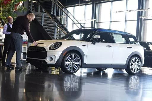 Salesmen examine an unsold 2024 Cooper Clubman S utility vehicle at a Mini dealership May 1, 2024, in Highlands Ranch, Colo. On Friday, May 31, 2024, the Commerce Department issues its report on consumer spending for April. (AP Photo/David Zalubowski, File)