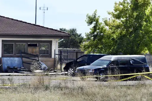 A hearse and debris can be seen at the rear of the Return to Nature Funeral Home, Oct. 5, 2023, in Penrose, Colo. (Jerilee Bennett/The Gazette via AP, File)