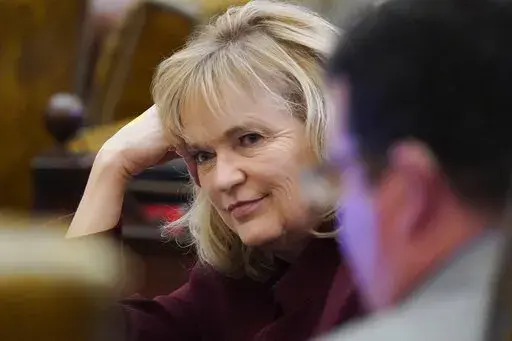 Rep. Becky Currie, R-Brookhaven, listens to a colleague during a recess in the House Chamber at the Capitol in Jackson, Miss., Wednesday, March 31, 2021.  he Mississippi House has voted to make the state's Medicaid program end a contract with health care giant Centene, although that plan could change later as lawmakers continue to debate issues.  (AP Photo/Rogelio V. Solis, File)