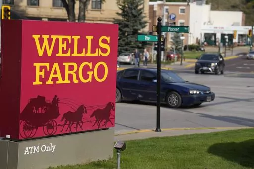 Motorists drive past a sign outside a branch of Wells Fargo bank, Wednesday, Sept. 20, 2023, in Deadwood, S.D. The Biden Administration is easing its restrictions on banking giant Wells Fargo, saying the bank has sufficiently fixed its toxic culture after years of scandals. The news sent Wells Fargo's stock up sharply in afternoon trading as investors speculated that the bank, which has been kept under a tight leash by regulators for years, may be able to start growing again. (AP Photo/David Zal